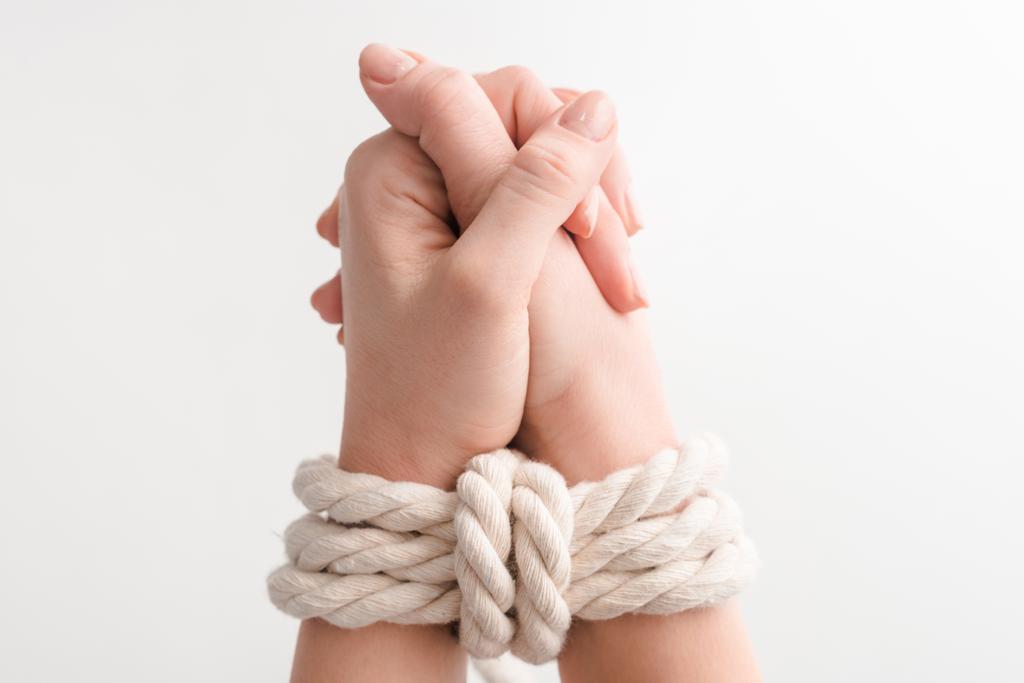 обрізаний вид жінки з мотузкою на молитовних руках ізольовані на білому, концепція прав людини
  - Фото, зображення