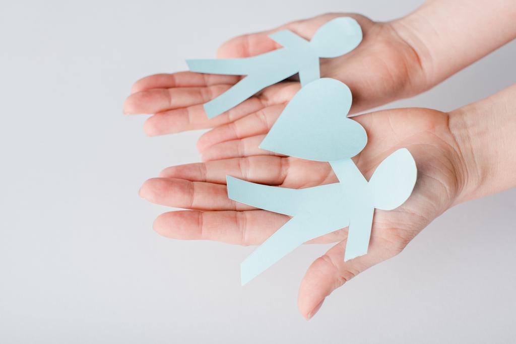 cropped view of woman holding figures of people cut from paper with heart, human rights concept  - Photo, Image