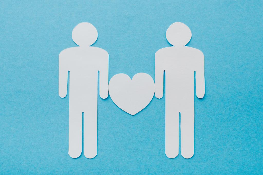 top view of paper cut figures of homosexual couple isolated on blue, human rights concept  - Photo, Image