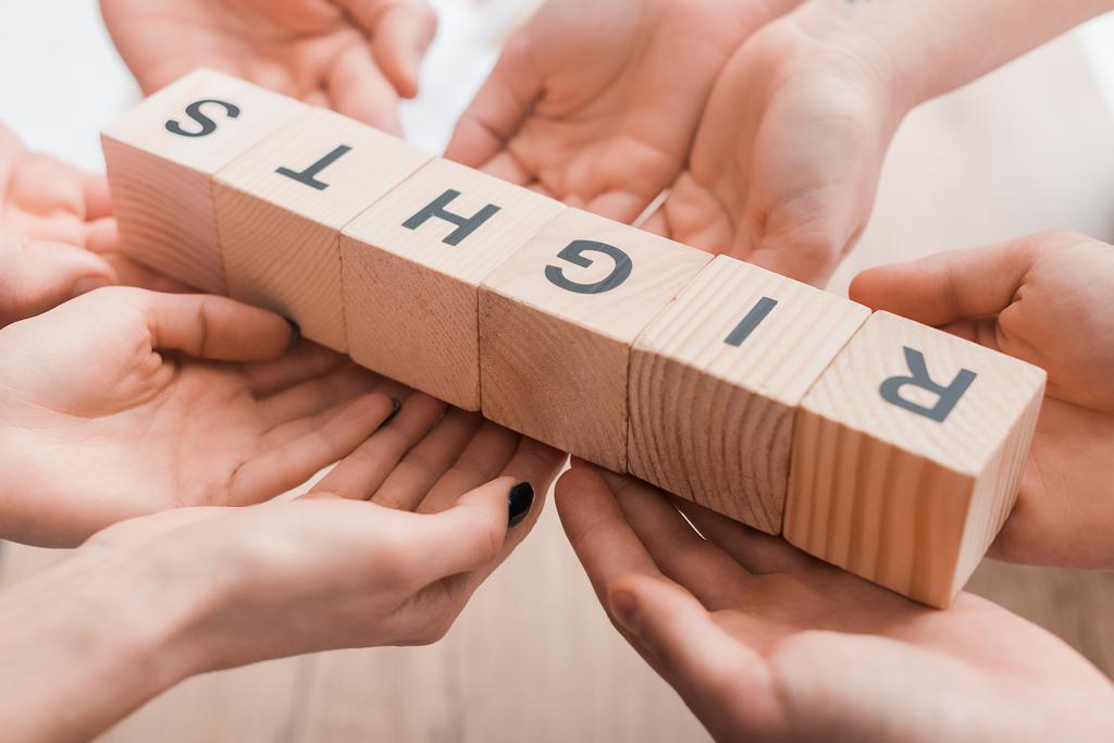cropped view of four people holding wooden cubes with rights lettering  - Photo, Image