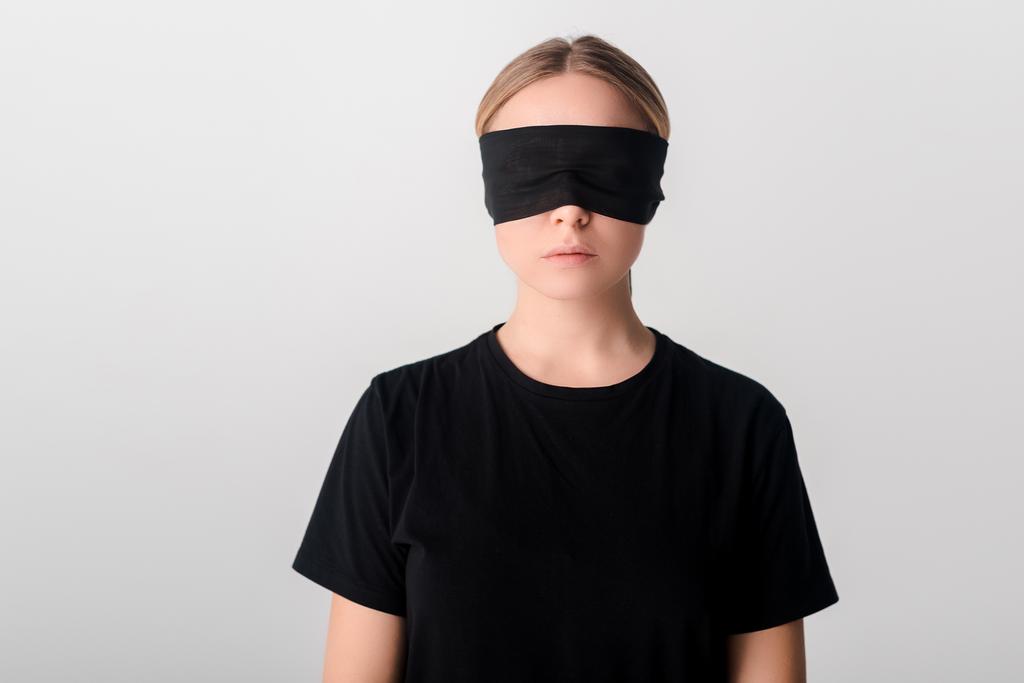 Junge Frau mit verbundenen Augen in schwarzem T-Shirt isoliert auf weißem, menschenrechtlichem Konzept  - Foto, Bild