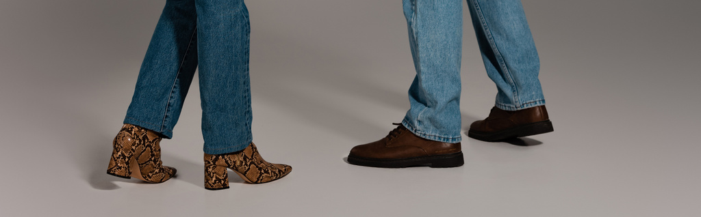 vue recadrée de l'homme et de la femme en jeans denim et chaussures sur fond gris
  - Photo, image