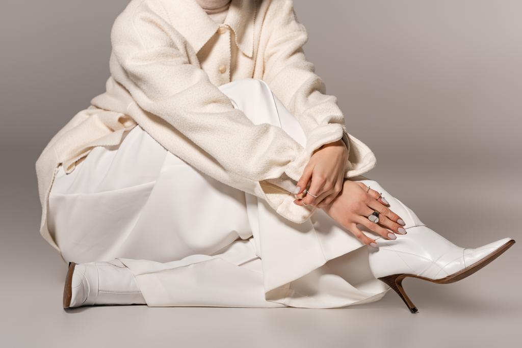 kivágott kilátás nő fehér kabátban és nadrág szürke háttér  - Fotó, kép