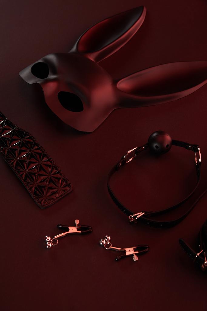 секс-іграшки в темному освітленні на червоному тлі
 - Фото, зображення