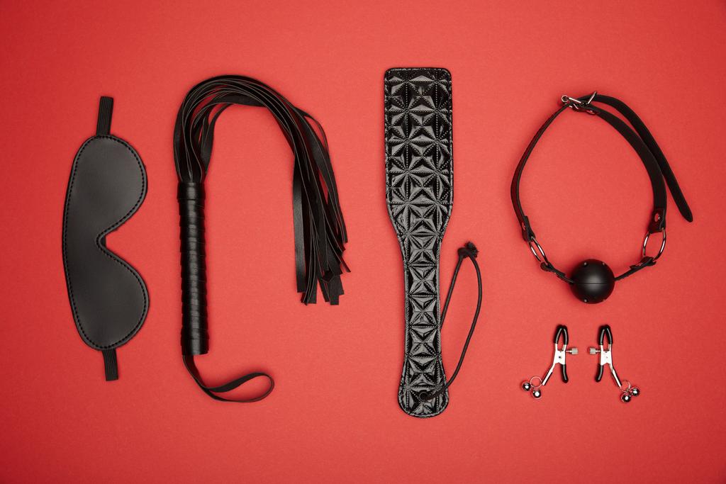 flat lay with various black sex toys isolated on red - Photo, Image