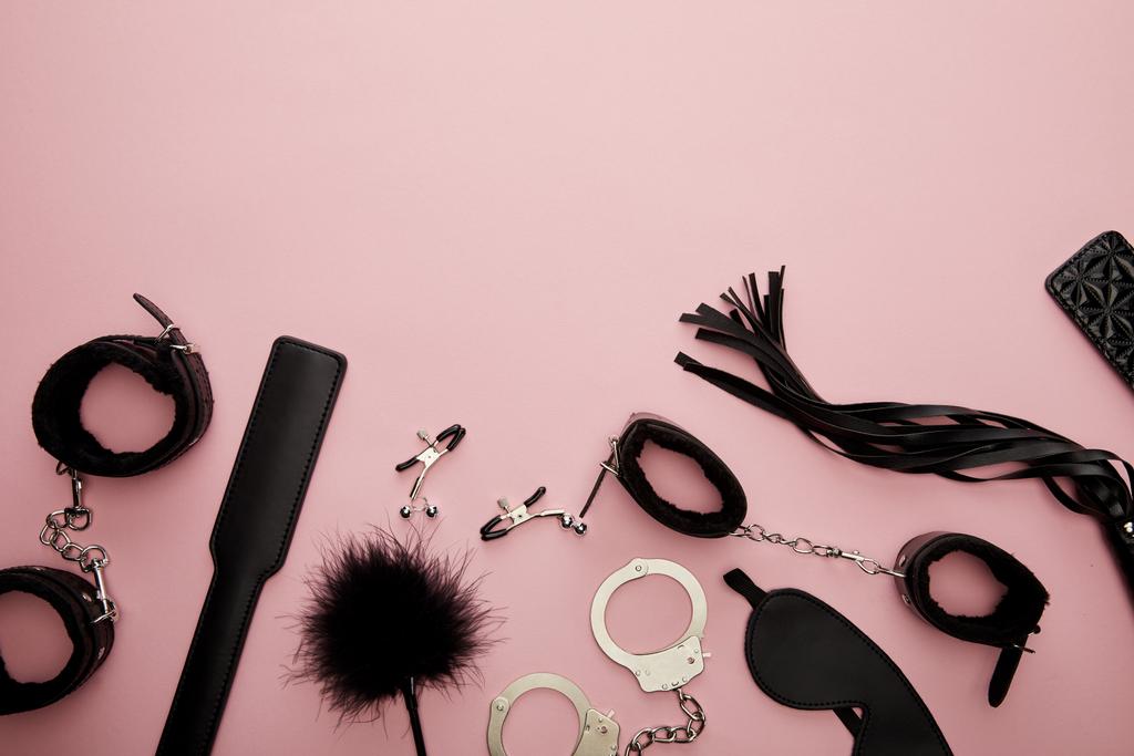 von oben auf schwarzem Sexspielzeug auf rosa Hintergrund - Foto, Bild