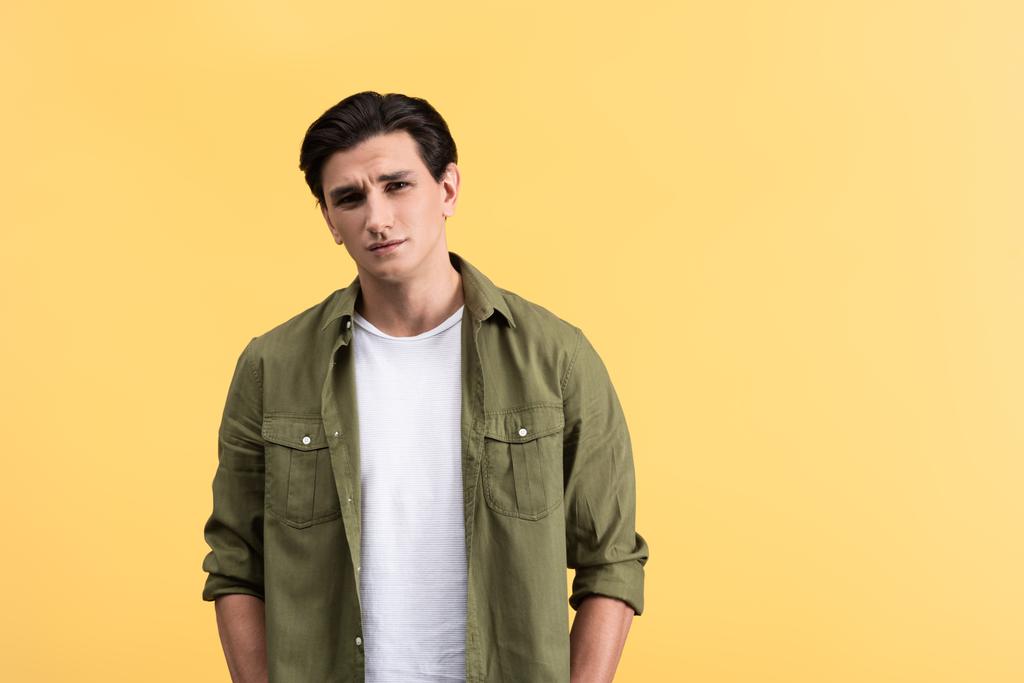 pensive brunette young man, isolated on yellow - Photo, Image
