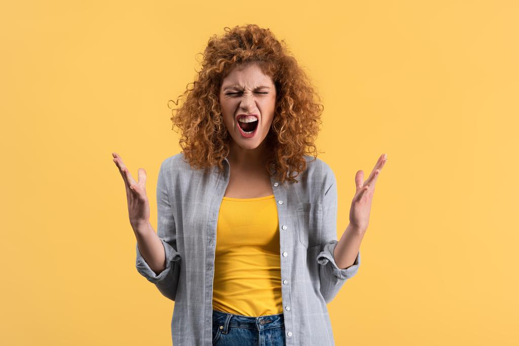 aggressive shouting redhead girl, isolated on yellow - 写真・画像