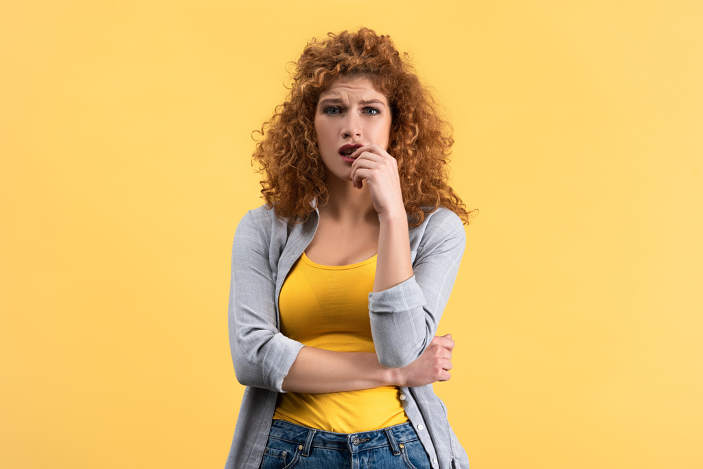 Jeune femme rousse inquiète, isolée sur jaune
 - Photo, image