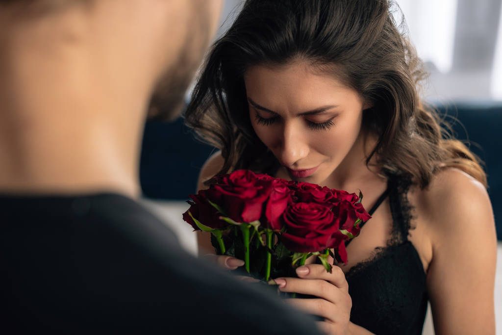 oříznutý pohled na atraktivní přítelkyni vonící růže od přítele ve 14 únor - Fotografie, Obrázek