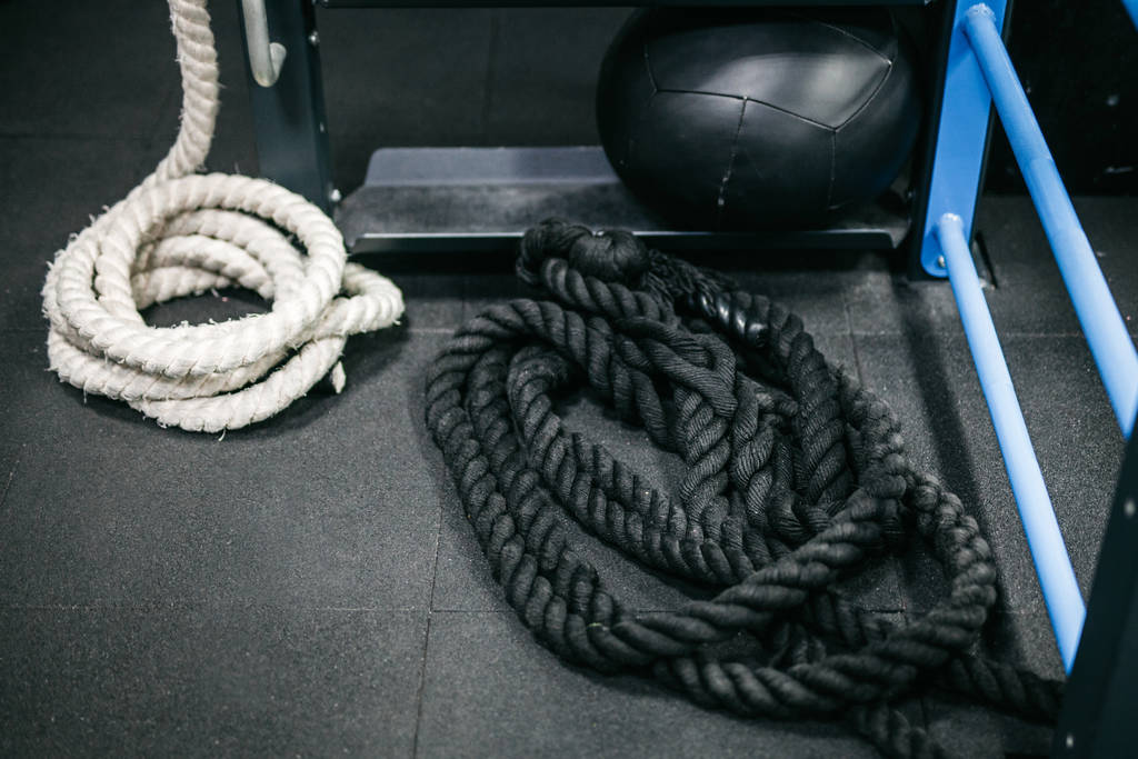 Schwarz-weißes Seil für das Training liegt in der Turnhalle - Foto, Bild