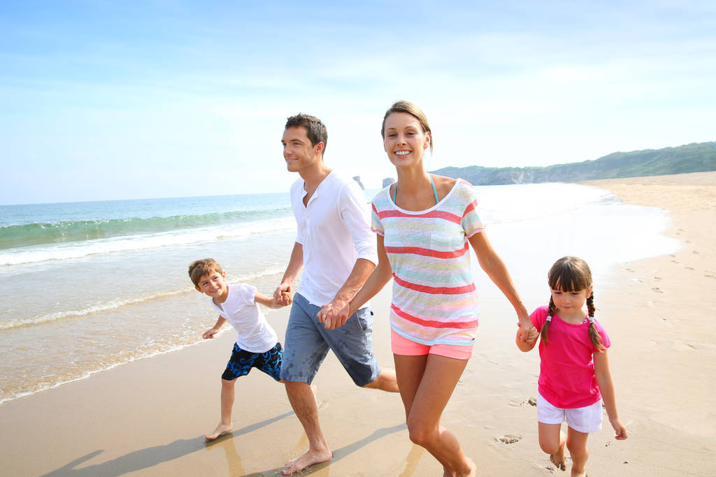 Glückliche Familie läuft am Strand - Foto, Bild