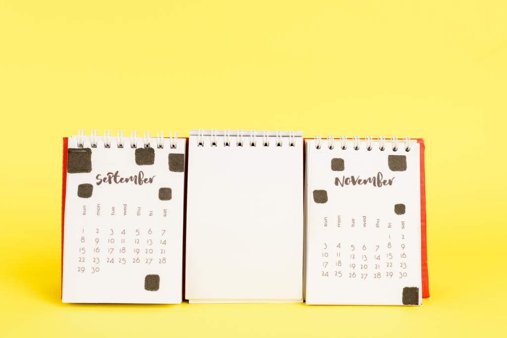 Calendário com meses de setembro e novembro e branco vazio no fundo amarelo
 - Foto, Imagem
