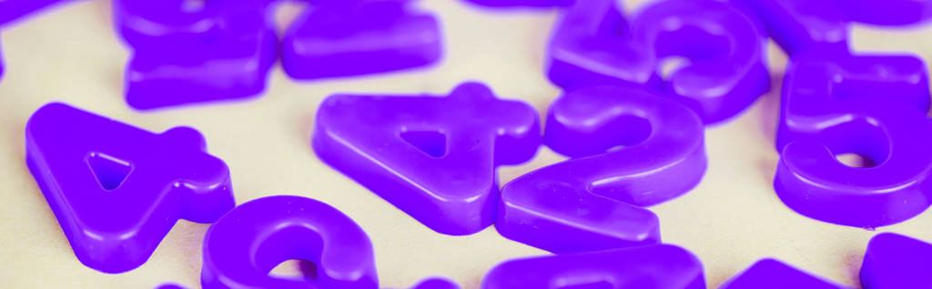 Панорамний знімок фіолетових пластикових номерів на білій поверхні
 - Фото, зображення