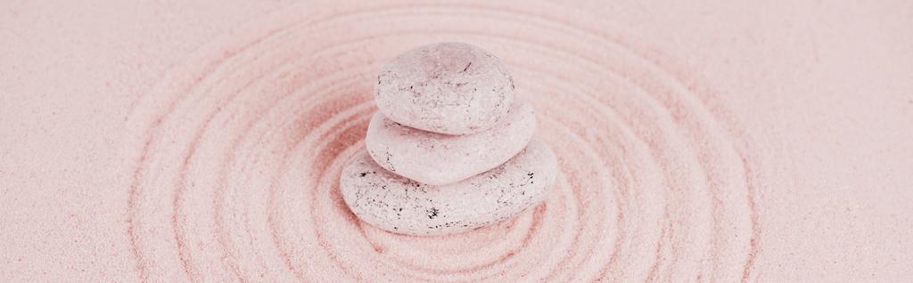 Tiro panorâmico de pedras zen na areia rosa com círculos
 - Foto, Imagem