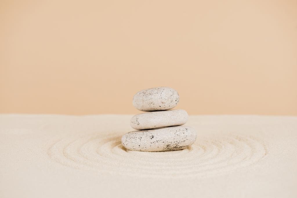 Piedras Zen sobre arena con círculos sobre fondo beige
 - Foto, Imagen