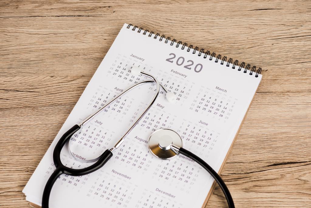 Wysoki kąt widzenia kalendarza 2020 roku ze stetoskopem na powierzchni drewnianej - Zdjęcie, obraz