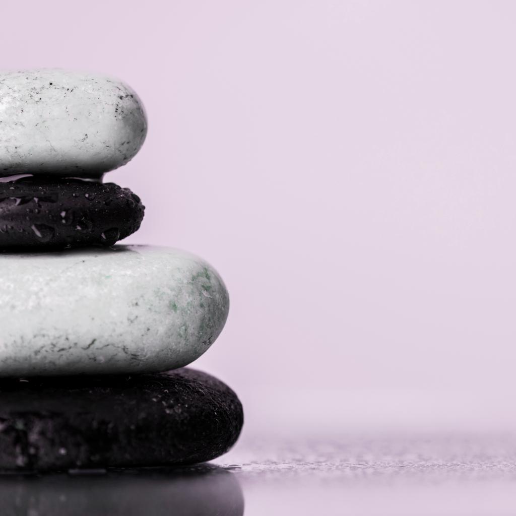 Vue rapprochée des pierres zen humides sur verre avec gouttes d'eau isolées sur violet
  - Photo, image
