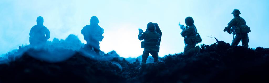 Harci jelenet játék katonák füst a kék háttér, panoráma lövés - Fotó, kép