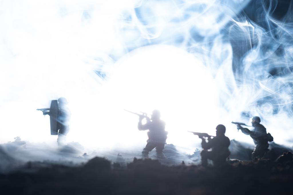Kampfszene mit Spielzeugsoldaten im Rauch auf schwarzem Hintergrund - Foto, Bild