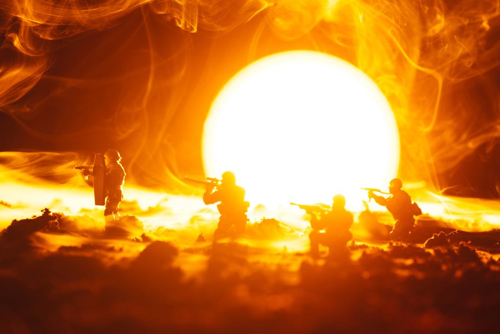 Cena de batalha de soldados de brinquedo em fumaça com o pôr do sol no fundo
 - Foto, Imagem