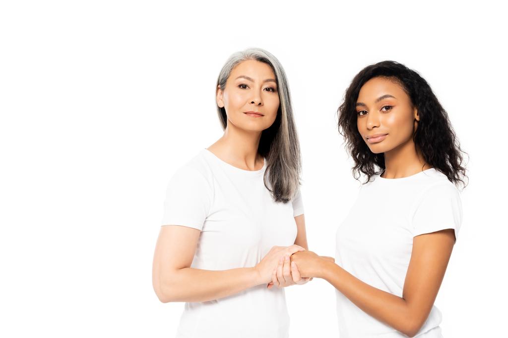 привлекательные африканские американские и азиатские женщины держатся за руки изолированные на белом
  - Фото, изображение