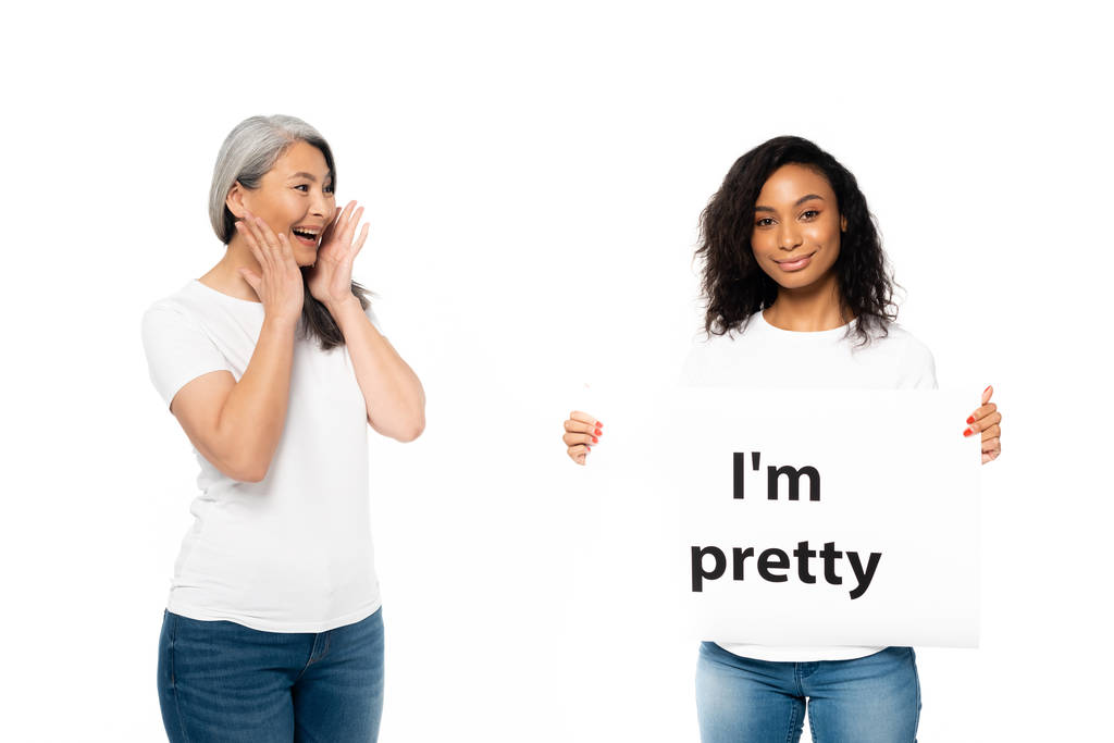 smiling african american and asian women near i`m pretty placard isolated on white  - Photo, Image
