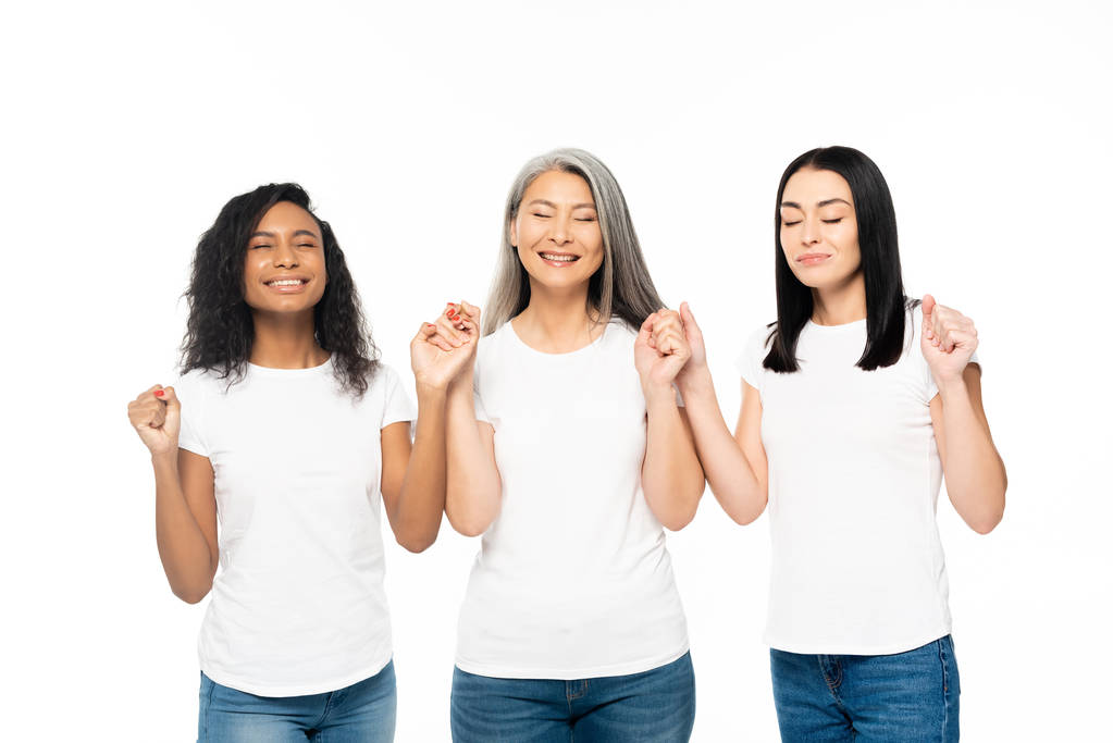 усміхнені мультикультурні жінки з закритими очима тримають руки ізольовані на білому
  - Фото, зображення