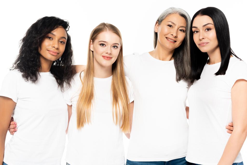 šťastný multikulturní ženy v bílých tričkách při pohledu na kameru izolované na bílém  - Fotografie, Obrázek