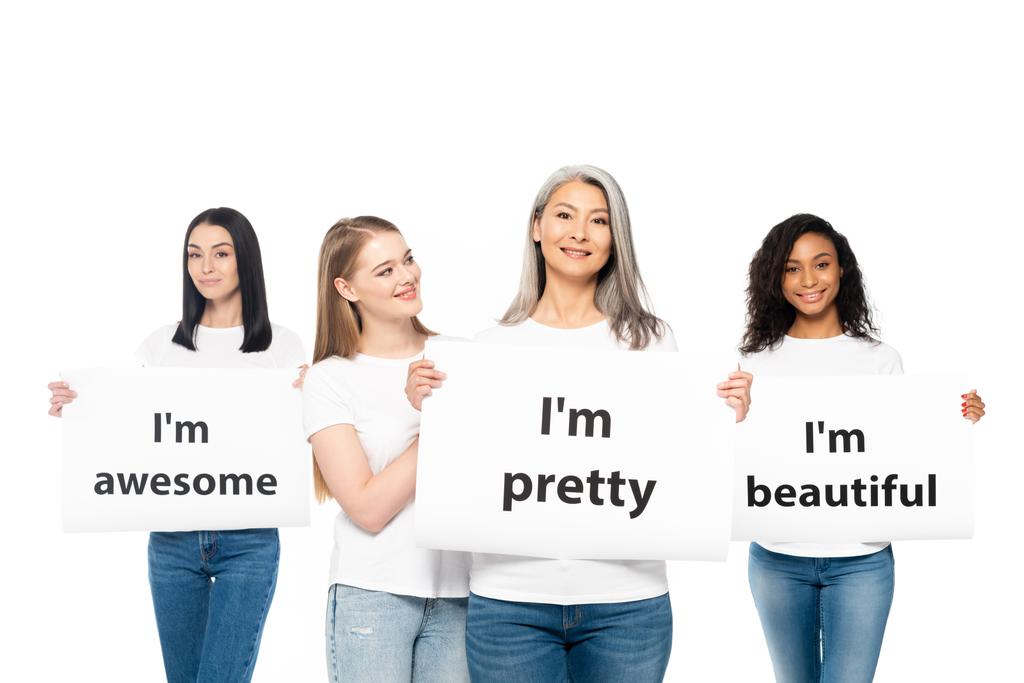 glückliche multikulturelle Frauen in Jeans mit Plakaten mit Schriftzug auf weißem Grund  - Foto, Bild