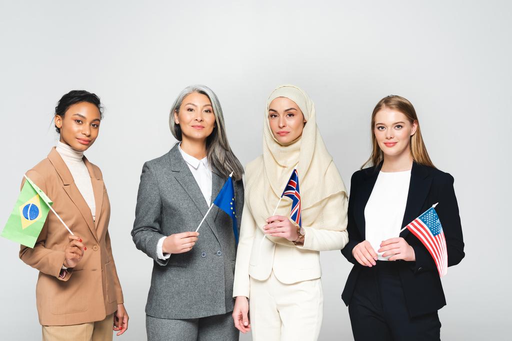 mujeres multiculturales con banderas de diferentes países aisladas en blanco
  - Foto, Imagen