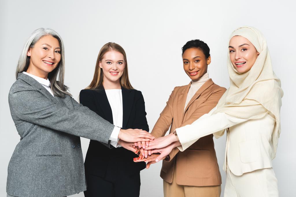 multiculturele zakenvrouwen die handen bij elkaar steken op wit  - Foto, afbeelding