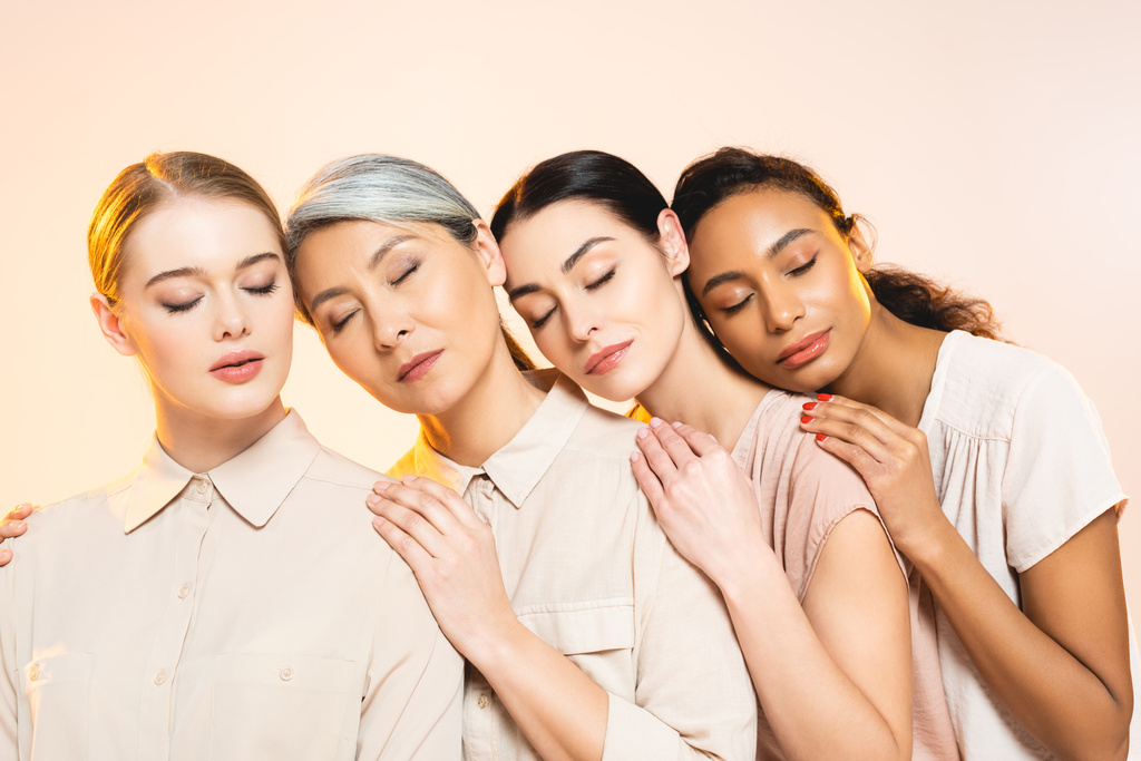 beautiful multicultural women with closed eyes isolated on beige  - Photo, Image