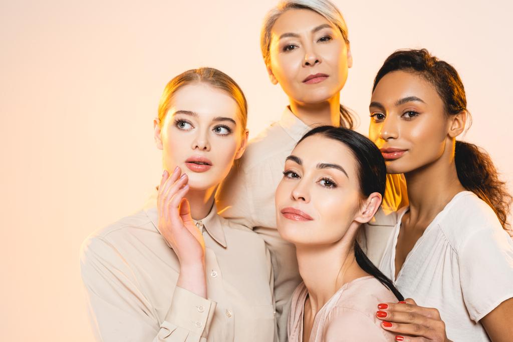 schöne multikulturelle Frauen mit Make-up isoliert auf beige  - Foto, Bild
