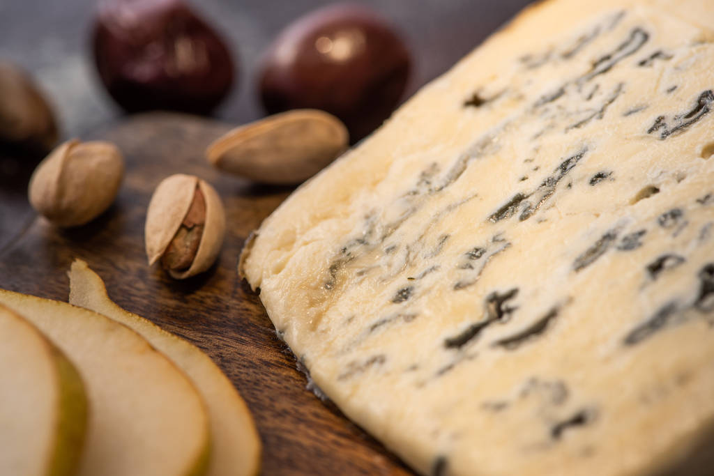 Dilimlenmiş armut ve fıstıklı Dorblu peynirin yakın görüntüsü - Fotoğraf, Görsel