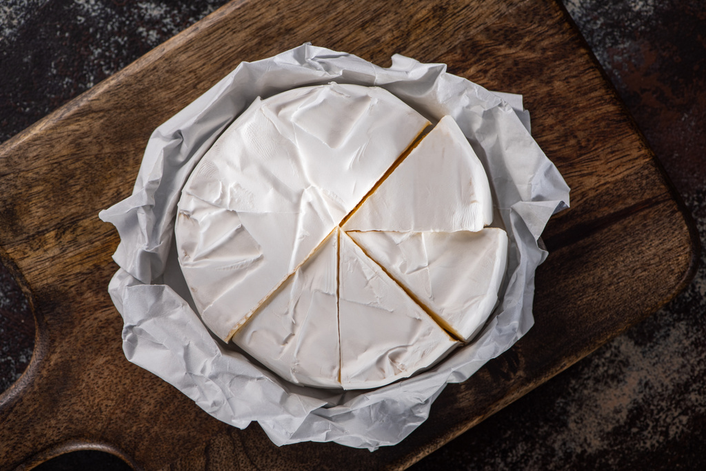 pohled shora na krájený sýr na dřevěné řezací desce - Fotografie, Obrázek