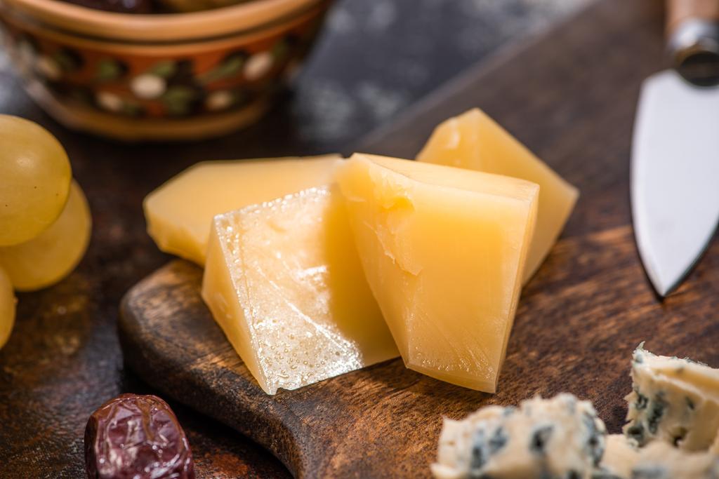 vista de perto de prato de queijo com azeitonas, uvas perto de faca
 - Foto, Imagem