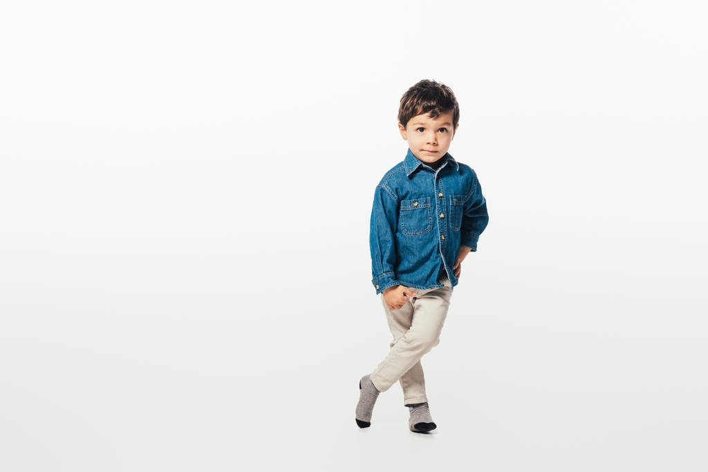 cute boy in denim shirt with hand on hip looking at camera on white background  - 写真・画像