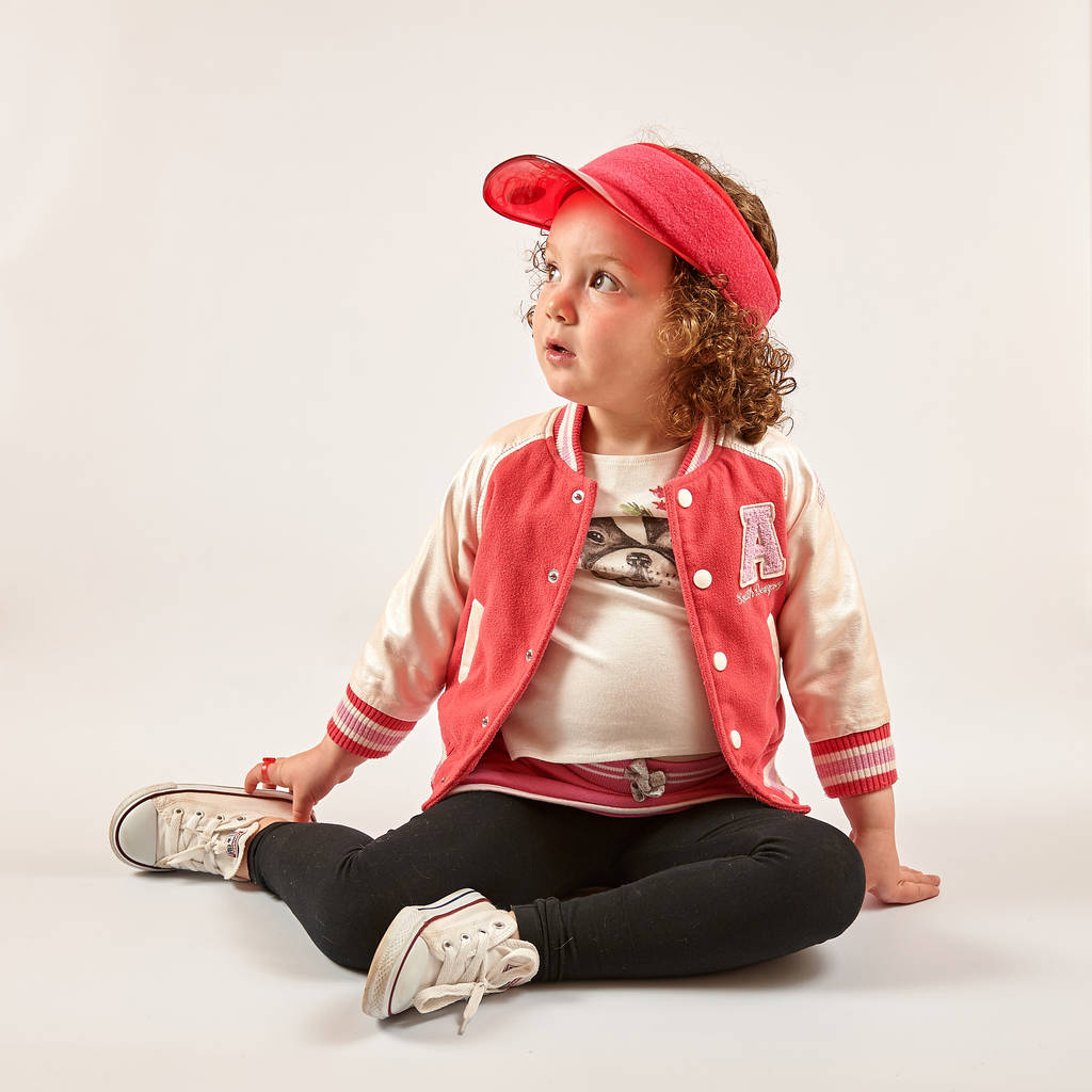 Niña con gorra roja de pie y sonriente
 - Foto, Imagen