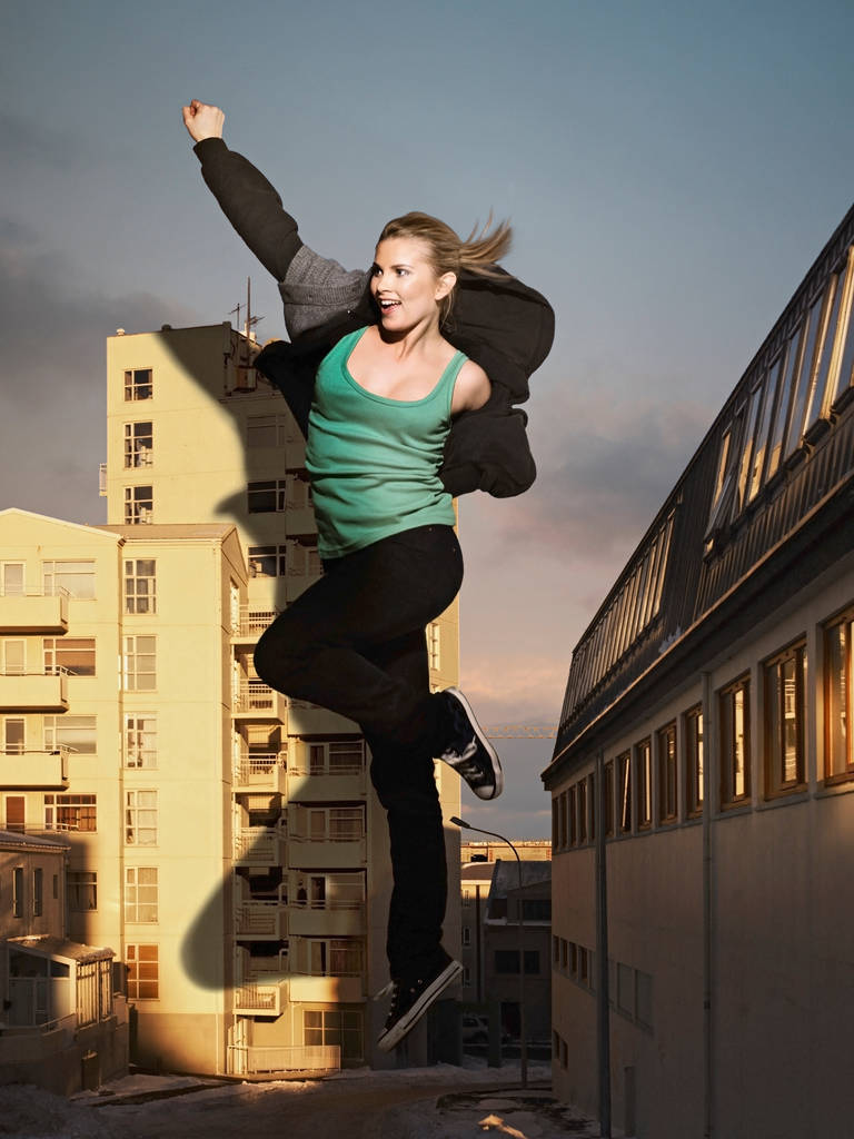 Υπερμεγέθης γυναίκα πηδάει δίπλα στο κτίριο - Φωτογραφία, εικόνα