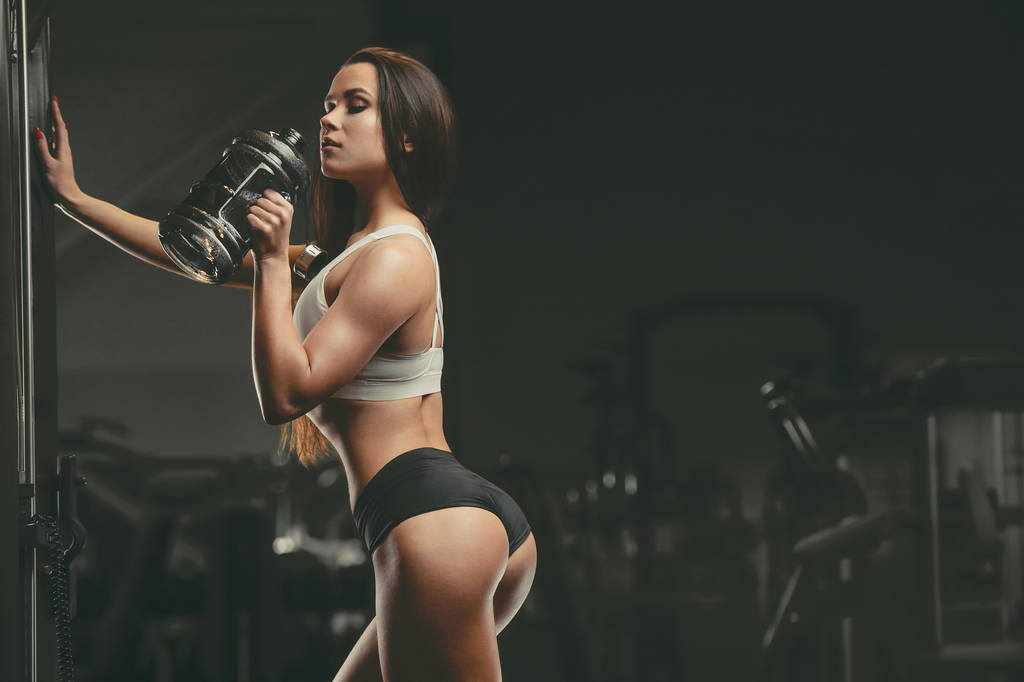 Fitnessfrau trinkt Wasser beim Training im Fitnessstudio - Foto, Bild