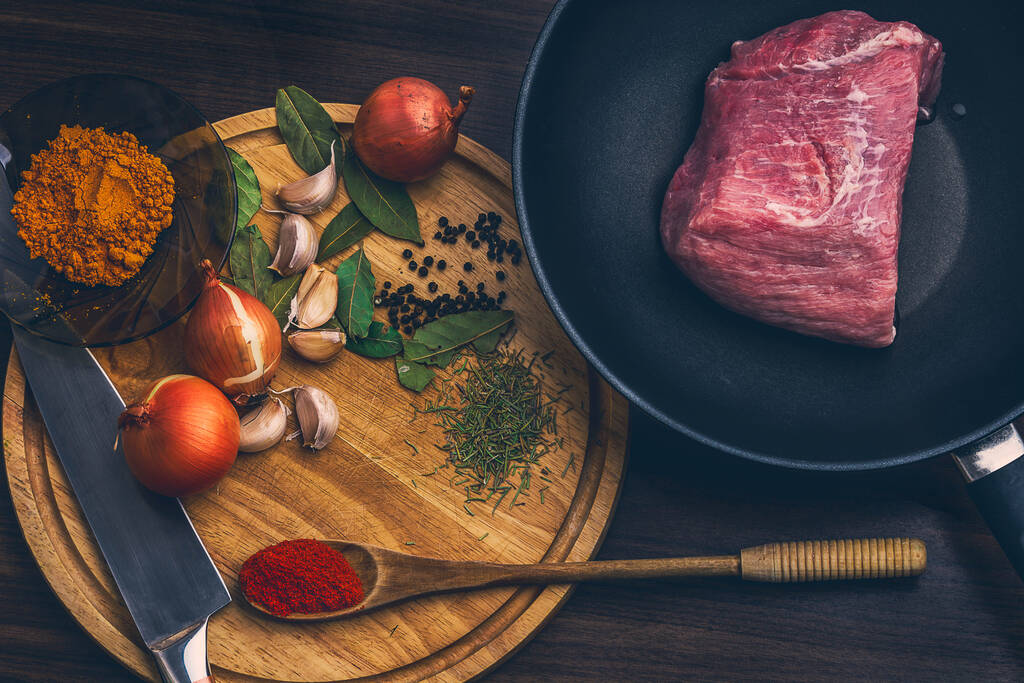 Nyers friss márványos hús Steak és a fűszerek az asztalon. Szemközti nézet. - Fotó, kép