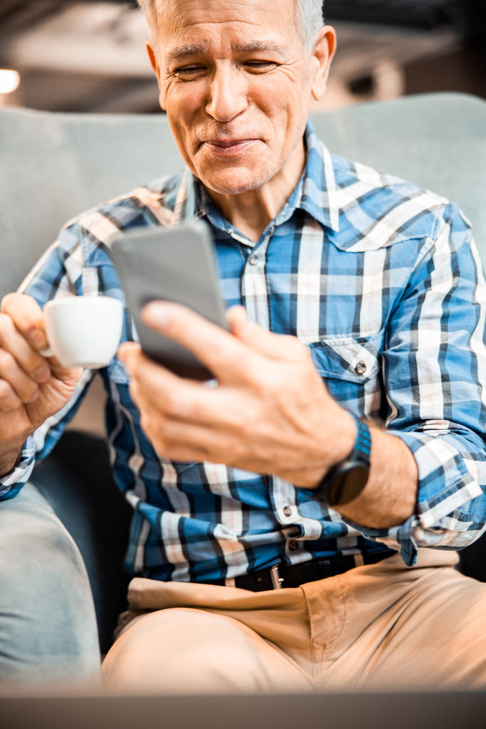 Boldog érett férfi használ okostelefon kávézóban - Fotó, kép