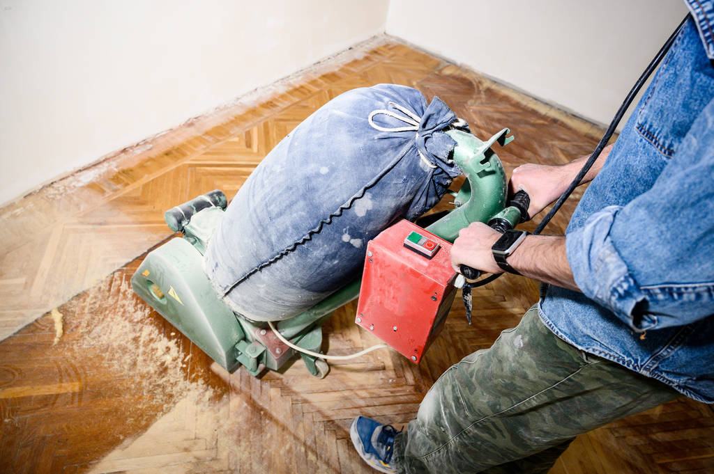 Lijado piso de madera dura con la máquina de pulir. Reparación en el apartamento
. - Foto, imagen