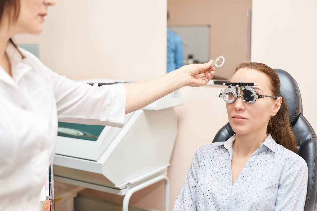 Augenärztin im Optikerlabor mit Patientin. Medizinische Diagnose der Augenpflege. Augenlidbehandlung - Foto, Bild