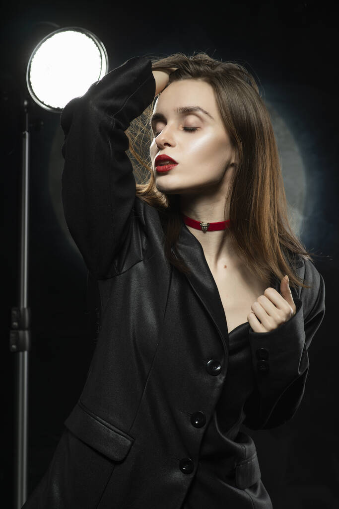 Mooi slank meisje model met rode lippen, met een zwarte blazer, - Foto, afbeelding