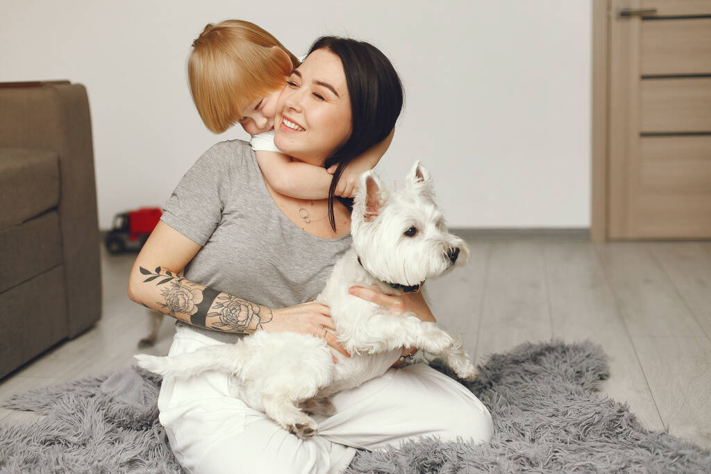 Madre e hijo pequeño diversión en casa con perro
 - Foto, imagen