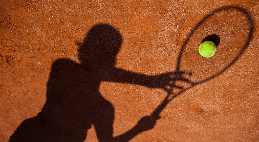 sombra de um jogador de tênis em ação em um campo de tênis
 - Foto, Imagem
