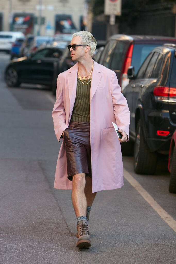 サルヴァトーレFerragamoファッションショー、ミラノファッションウィークストリートスタイルの前にピンクのコートと茶色の革のズボンを持つ男  - 写真・画像