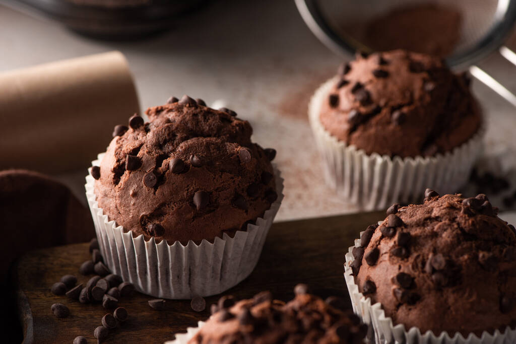 close up view of fresh chocolate muffins on wooden cutting board - Fotoğraf, Görsel